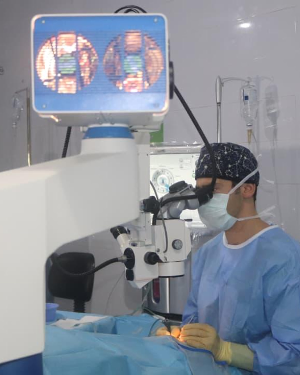 Ao microscópio cirúrgico na missão de 2025, com o monitor da sala