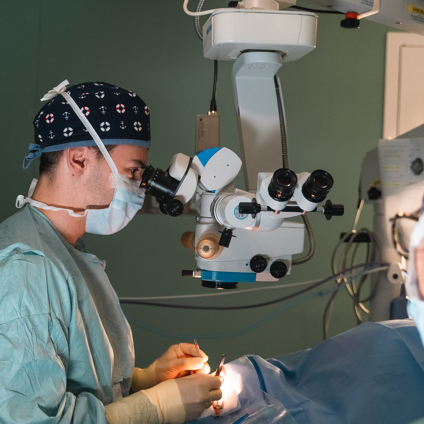 Dr. André Magalhães Oliveira durante uma cirurgia oftalmológica, ao microscópio cirúrgico